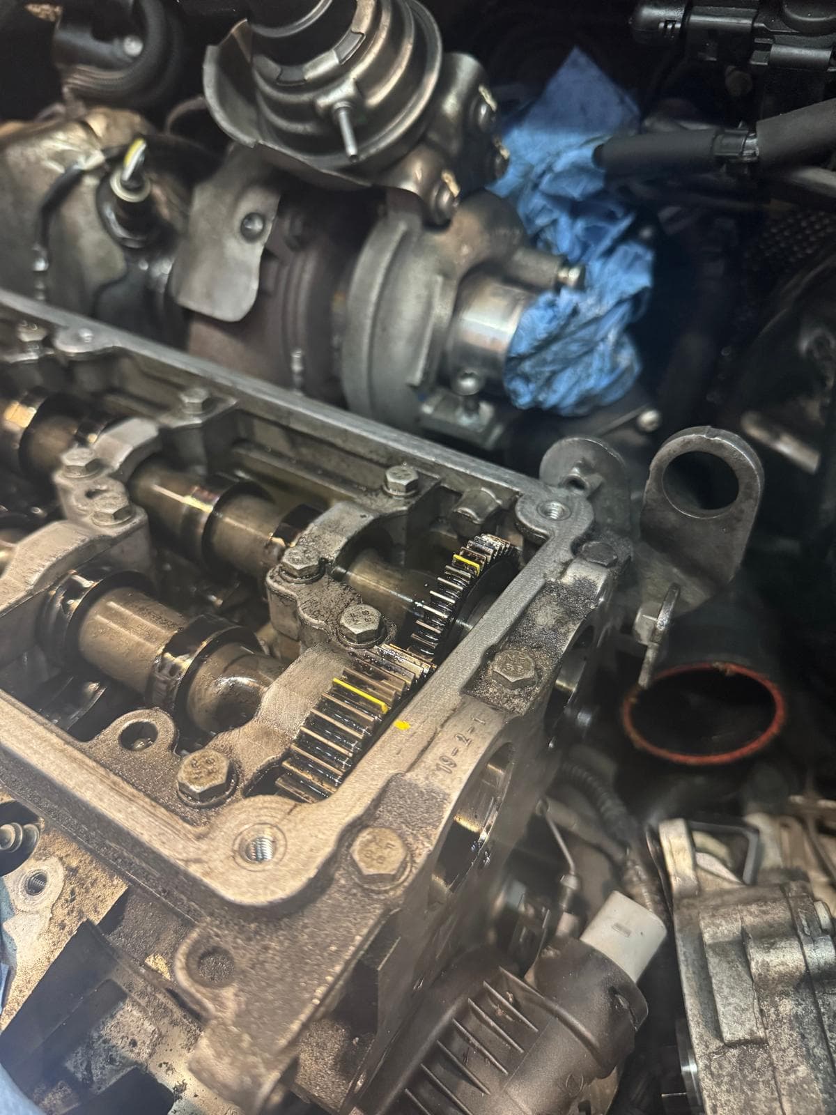 Geöffneter Motor mit sichtbaren Nockenwellen und Werkstattkontext