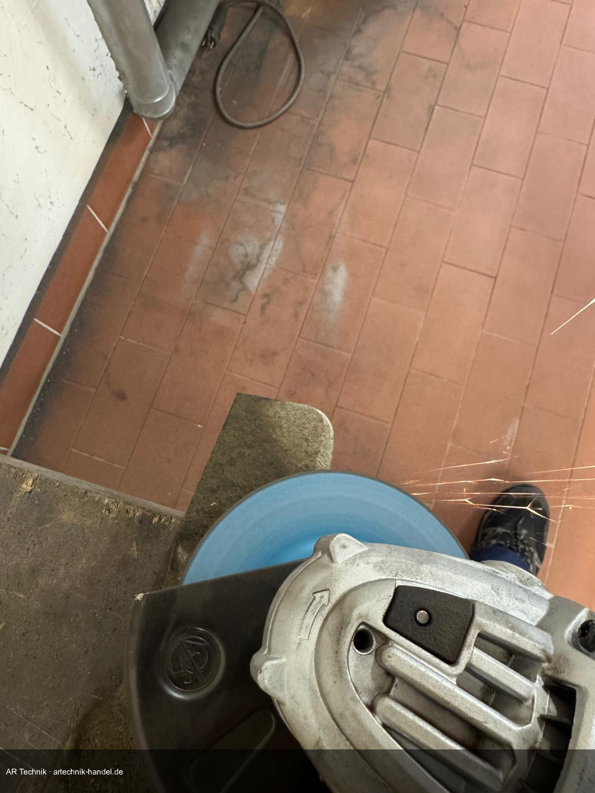 Winkelschleifer beim Schärfen des Mähmessers – Funken sichtbar, kurze Schleifstöße