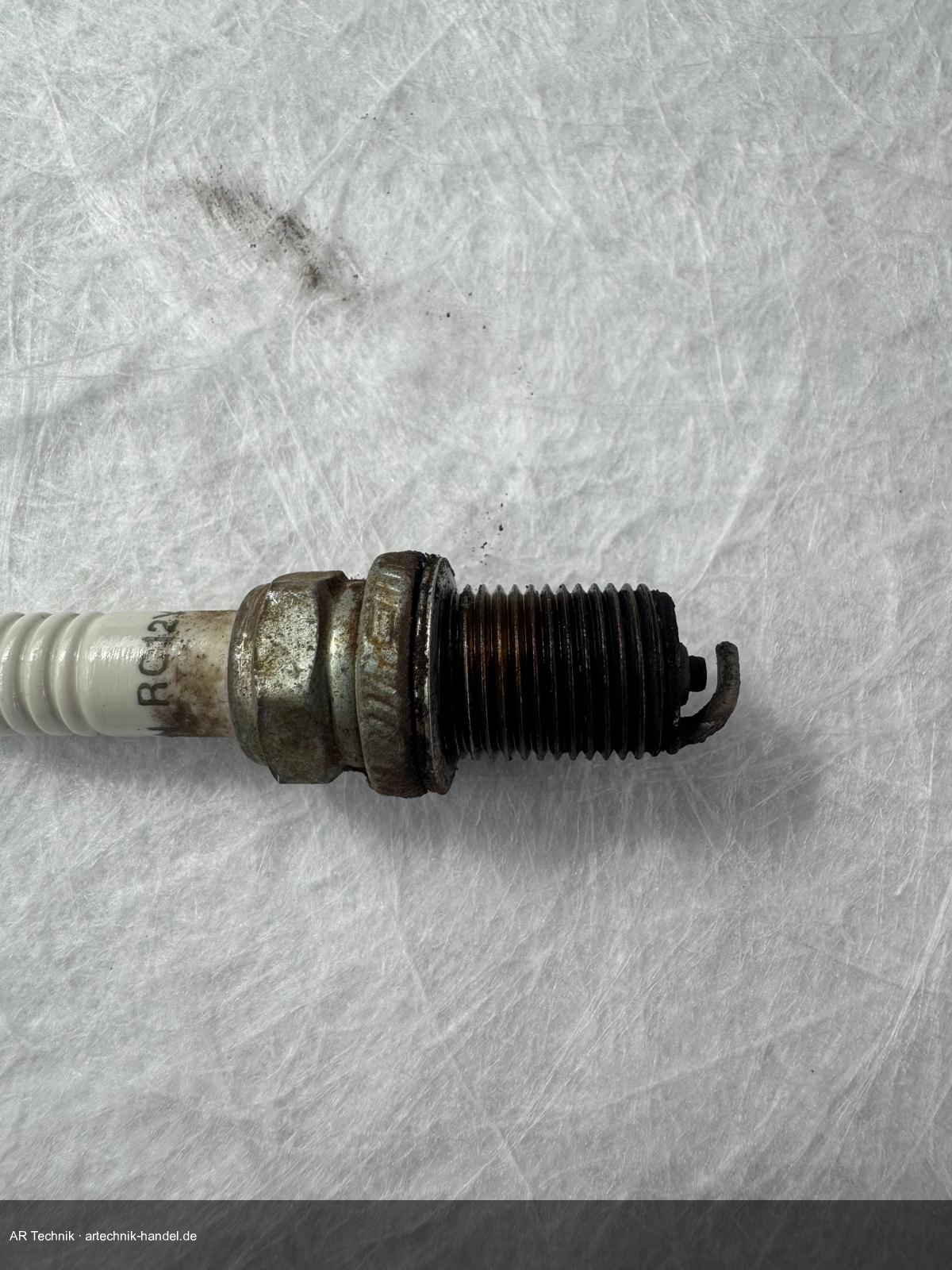 Vier Zündkerzenzustände im Vergleich – rußig, weiß, ölig, normal verschlissen